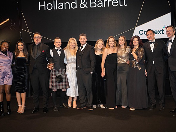 Holland & Barrett insight team on stage at the 2023 MRS Awards, pictured with MRS Awards host Sophie Duker